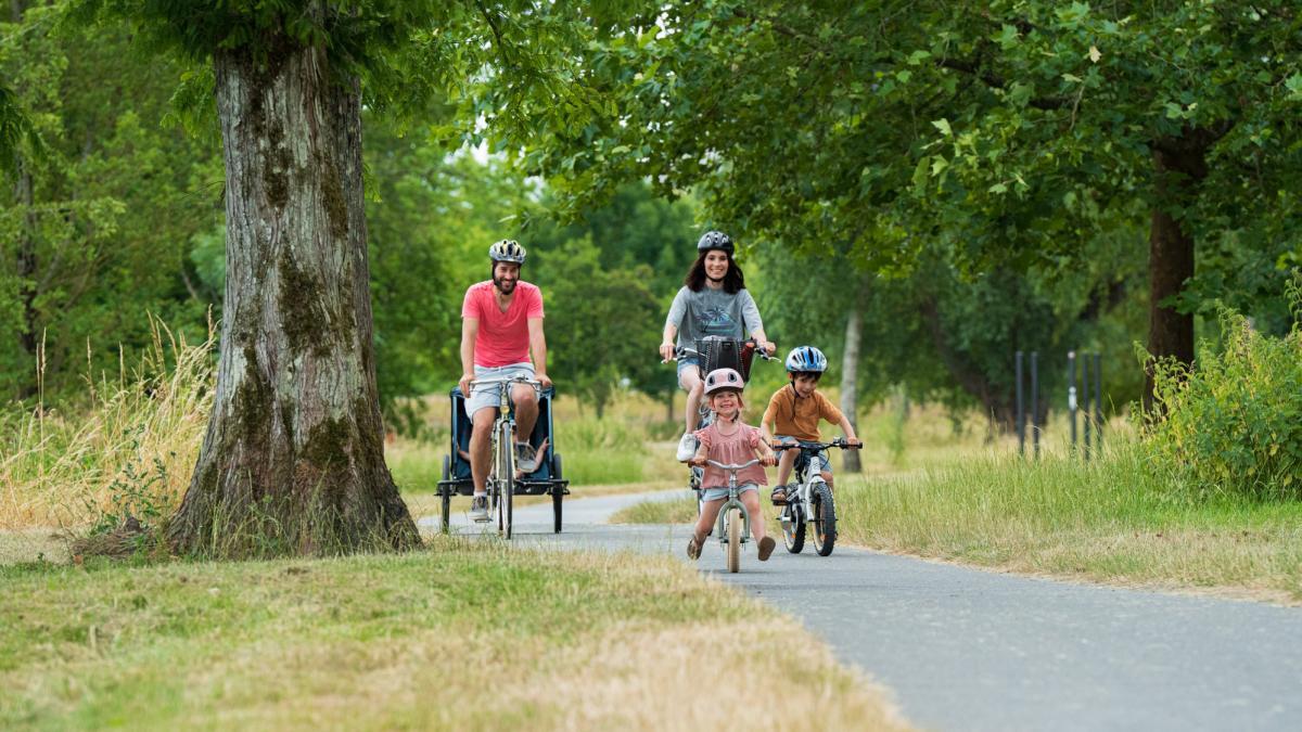 un couple et deux enfants font du vélo