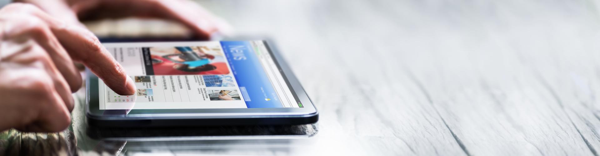 Mains d'une personne qui touchent l'écran d'une tablette