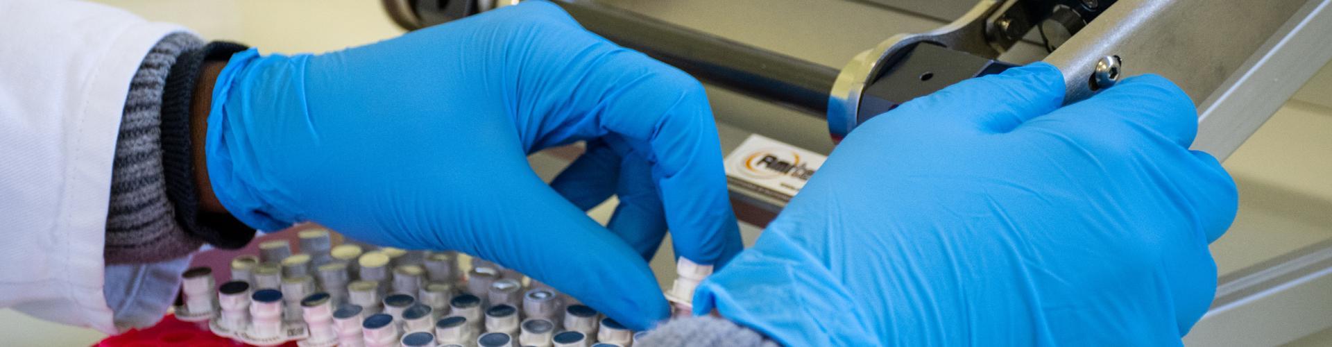 Mains avec des gants qui manipulent des analyses