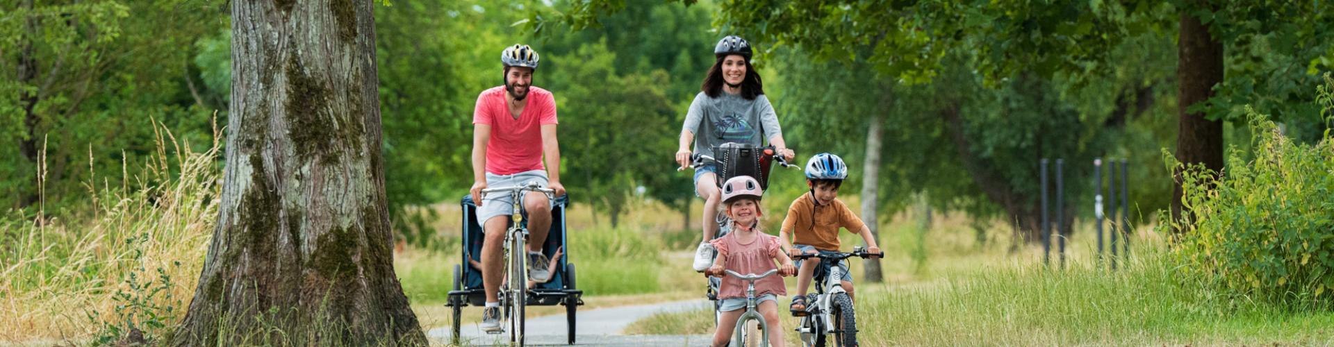 un couple et deux enfants font du vélo