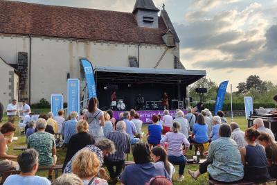 concert en plein air avec le public assis devant la scène - Agrandir l'image 20 sur 39, fenêtre modale