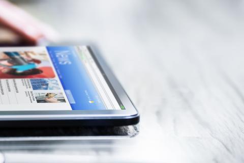 Mains d'une personne qui touchent l'écran d'une tablette
