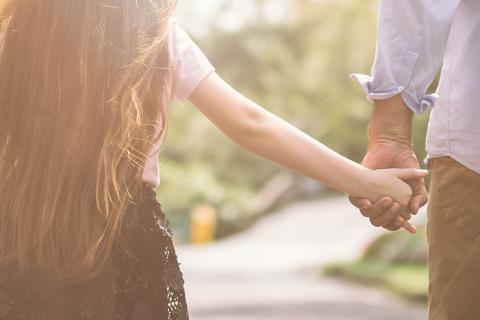 2 adultes donnent la main à une jeune fille