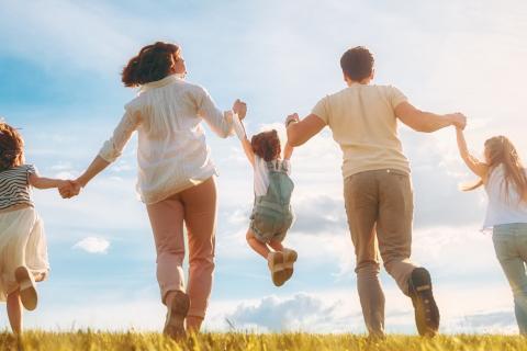 des enfants et leurs parents courent dans un champ