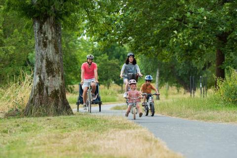 un couple et deux enfants font du vélo