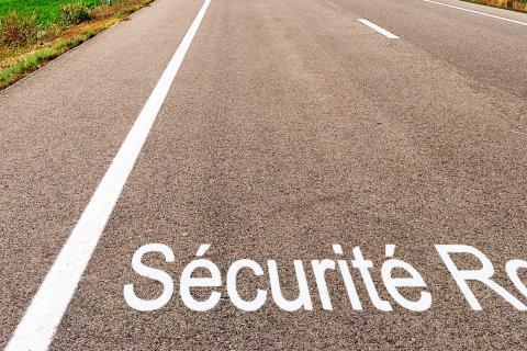 Route avec bandes blanches et écriture sécurité routière